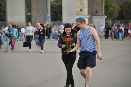 Москва.  Мужчина дарит девушке цветы во время празднования  Дня Воздушно-десантных войск и 85-летия образования Воздушно-десантных войск РФ на территории ВДНХ.