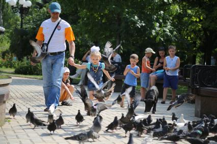 Украина, Донецк. Мужчина с девочкой гуляют по бульвару.