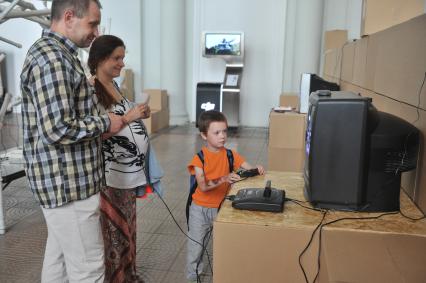 Москва. Мужчина с ребенком играют в приставку Sega на выставке `100 гаджетов, которые изменили мир` в Политехническом музее на ВДНХ