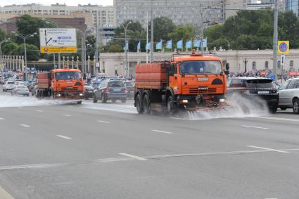 Москва. Поливальные машины моют дорогу  на Крымском мосту.