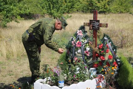 Украина, Донецкая область. Ополченец с позывным Поэт у памятного креста на месте гибели фотокорреспондента МИА `Россия сегодня` Андрея Стенина.