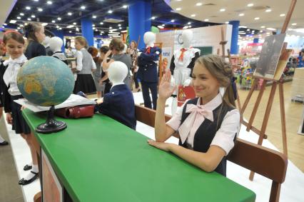 Москва. Девочка сидит за школьной партой во время выставки школьной формы в столичном `Детском мире`.