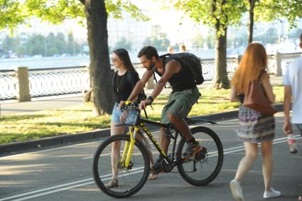 Москва.  Молодой человек катается на велосипеде в Парке Горького.