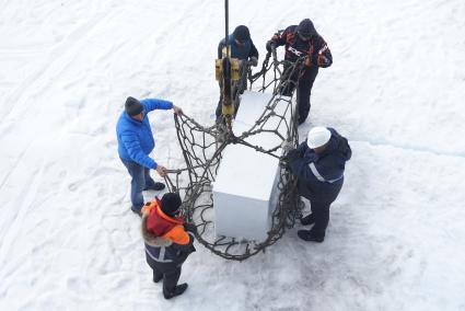 Полярники грузят холодильник с продуками с сезонной дрейфующей станции \"Северный полюс 2015\" в сетку, для погрузки в трюм ледокола \"Капитан Драницын\" перед эвакуацией на большую землю. Северный полюс. Северный ледовитый океан