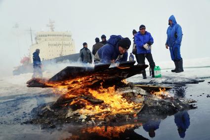 Полярники сжигают остатки стройматериалов и мусор с  сезонной дрейфующей станции \"Северный полюс 2015\" из Арктики, на ледокол \"Капитан Драницын\" перед эвакуацией на большую землю. Северный полюс. Северный ледовитый океан