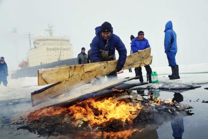 Полярники сжигают остатки стройматериалов и мусор с  сезонной дрейфующей станции \"Северный полюс 2015\" из Арктики, на ледокол \"Капитан Драницын\" перед эвакуацией на большую землю. Северный полюс. Северный ледовитый океан