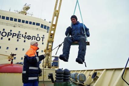 Инженер-оканолог Кирилл Фильков (в качелях) поднимается на борт ледокола \"Капитан Драницын\" после установки GPS-буя Argos отслеживающего дрейф льдины. Ледокол \"Капитан Драницын\". Северный ледовитый океан