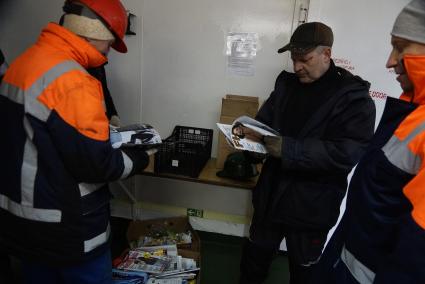 Экипаж ледокола \"Капитан Драницын\" в трюме листают мужские журналы с сезонной дрейфующей станции \"Северный полюс 2015\" перед эвакуацией на большую землю. Северный полюс. Северный ледовитый океан
