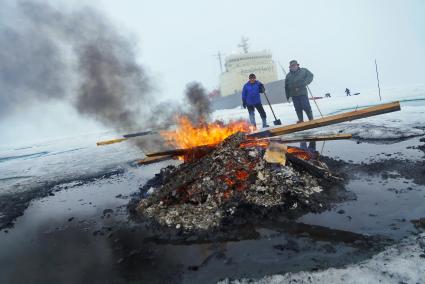 Полярники сжигают остатки стройматериалов и мусор с  сезонной дрейфующей станции \"Северный полюс 2015\" из Арктики, на ледокол \"Капитан Драницын\" перед эвакуацией на большую землю. Северный полюс. Северный ледовитый океан