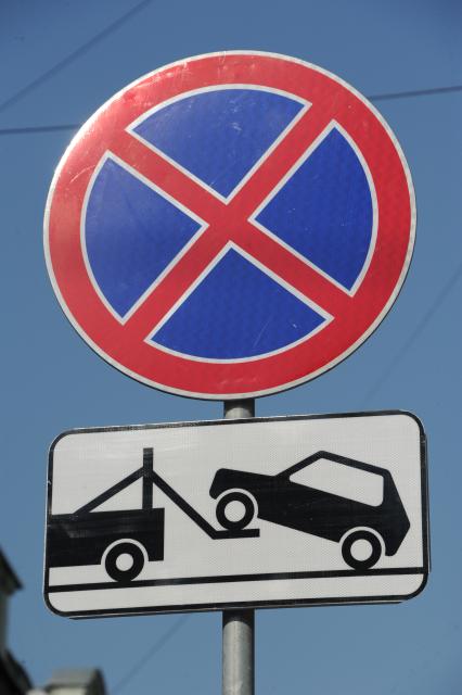 Москва. Дорожные знаки `Остановка запрещена` и `Работает эвакуатор`.