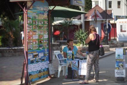 Крым. Алушта. Женщина на набережной продает билеты на морские экскурсии.