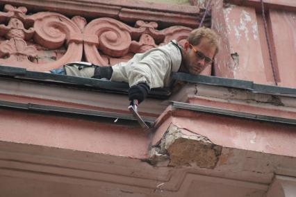Нижний Новгород. Промышленный альпинист ремонтирует фасад здания.