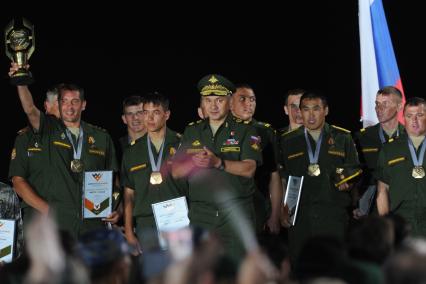 Московская область, д.Алабино. Министр обороны РФ Сергей Шойгу (в центре) поздравляет победителей чемпионата мира по `Танковому биатлону` в рамках `Армейских международных игр - 2015`.