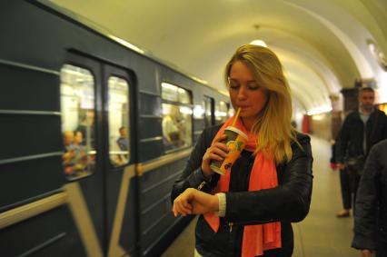 Москва. Девушка пьет кофе на станции Московского метрополитена.