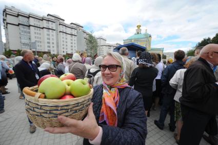 Москва.  Женщина держит в руках корзину с яблоками во время празднования Преображения Господня (Яблочного Спаса) на Преображенской площади.