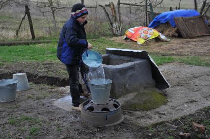 Ингушетия. Станица Вознесенская. Мальчик наливает воду из колодца.