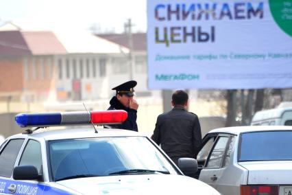 Ингушетия. Назрань. Полицейский проверяет документы у водителя на дороге.