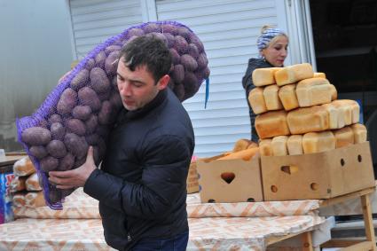 Ингушетия. Назрань. Мужчина с мешком картошки на рынке.