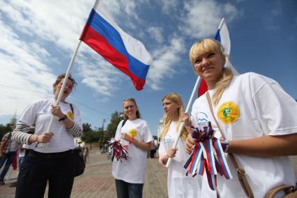 Ставрополь. Девушки раздают ленточки в цветах флага РФ во время празднования Дня российского флага.