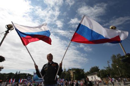 Ставрополь. Мужчина размахивает флагами РФ во время празднования Дня российского флага.