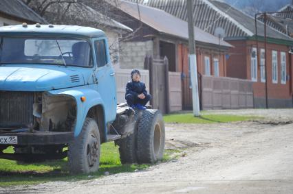 Чечня. Урус-Мартановский район. Мальчик сидит на грузовике.