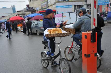 Чечня. Грозный. Продавец лепешек угощает выпечкой другого.