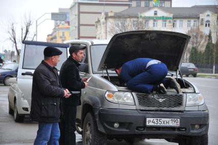 Чечня. Грозный. Мужчина ремонтирует автомобиль.