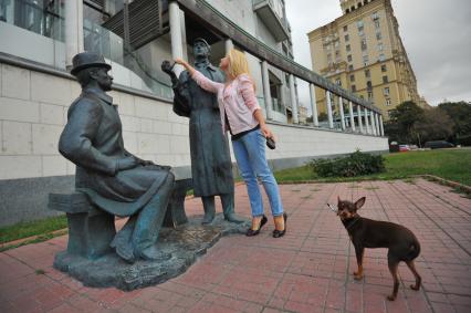 Москва. Девушка загадывает желание у памятника Шерлоку Холмсу и доктору Ватсону перед зданием посольства Великобритании на Смоленской набережной, 10.