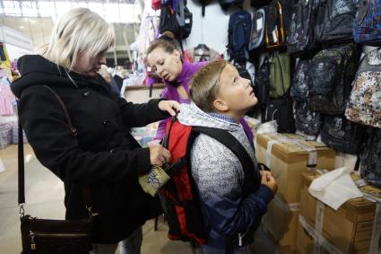 Екатеринбург. Мама с сыном выбирают рюкзак на школьном базаре.