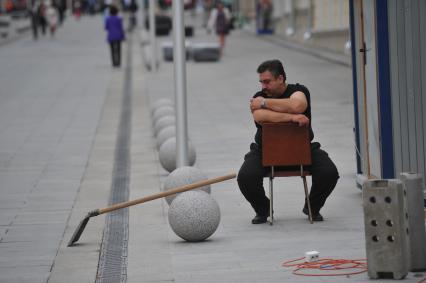 Москва. Мужчина сидит на стуле посреди улицы.