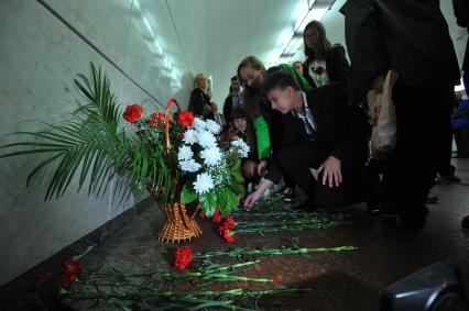 Москва.  Люди возлагают цветы во время акции памяти жертв терроризма в вестибюле станции метро Лубянка.