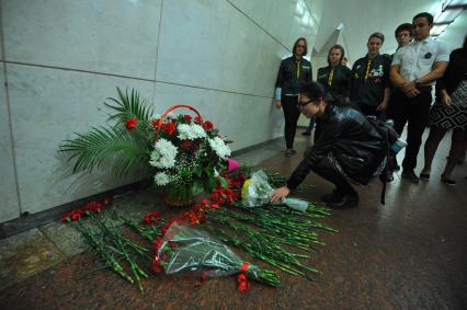 Москва.  Девушка возлагает цветы во время акции памяти жертв терроризма в вестибюле станции метро Лубянка.