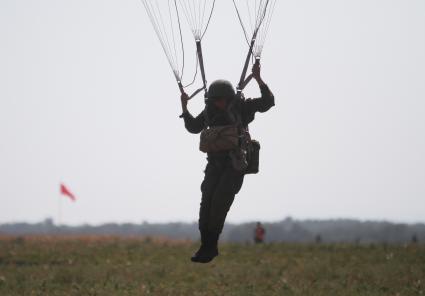 Краснодарский край, полигон Краснооктябрьский. Военнослужащий ВДВ России в момент приземления во время совместных учений сил ВДВ России, Белоруссии и Сербии `Славянское братство`.