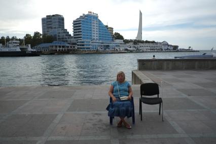Севастополь. Девушка сидит на набережной.