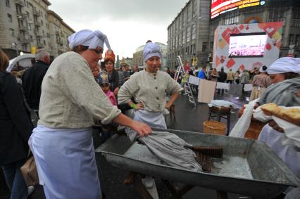 Москва. Женщина стирает одежду  во время празднования Дня города на Тверской улице.