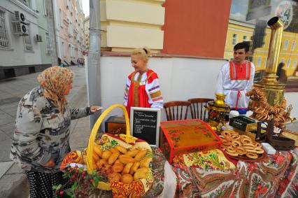 Москва. Пожилая женщина покупает пирожки на улице Большая Ордынка.