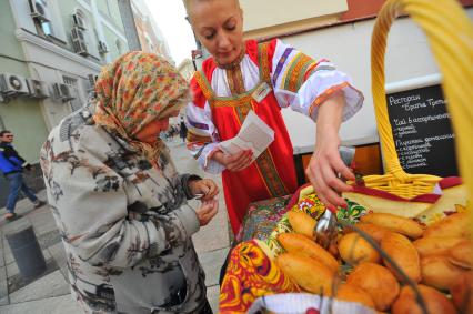 Москва. Пожилая женщина покупает пирожки на улице Большая Ордынка.