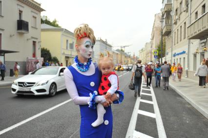 Москва.  Женщина с ребенком на руках  на улице Большая Ордынка.