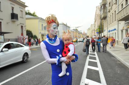 Москва.  Женщина с ребенком на руках  на улице Большая Ордынка.