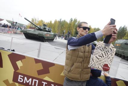 Нижний Тагил. Мужчина делает селфи на фоне танка Т-14 на гусеничной платформе `Армата` на 10-ой международной выставке вооружений `Russia Arms Expo - 2015`.