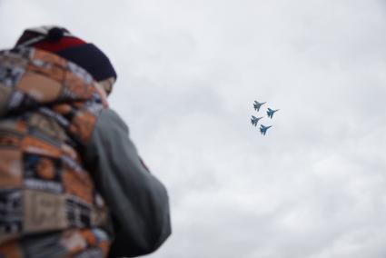 Нижний Тагил. Посетители наблюдают за полетом пилотажной группы `Соколы России` Су-27 на 10-ой международной выставке вооружений `Russia Arms Expo - 2015`.