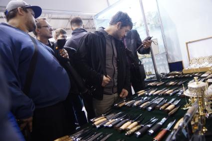 Нижний Тагил. Посетители изучают ножи у стенда `Златоустовской оружейной компании` на 10-ой международной выставке вооружений `Russia Arms Expo - 2015`.