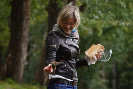 Екатеринбург. Девушка кормит птиц хлебом в Харитоновском парке.