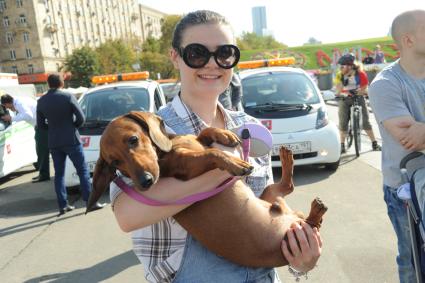Москва. Девушка держит таксу на руках во время велокарнавала, приуроченного ко Всемирному дню без автомобиля, в Парке Победы.