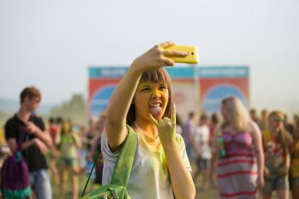 Красноярск. Девушка делает селфи на Фестивале красок Холи.