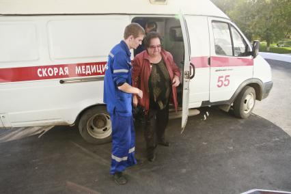 Барнаул. Врач помогает женщине выйти из машины скорой помощи.