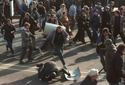 Москва. 1993 год. Октябрьский путч. Митингующий подбегает к упавшему милиционеру.