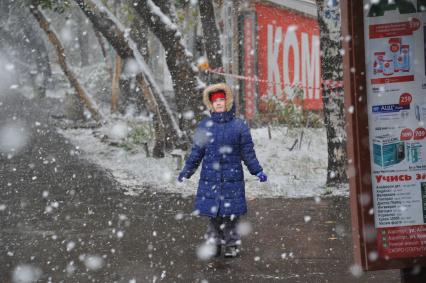 Москва.   Первый снег. Девочка смотрит на падающий снег.
