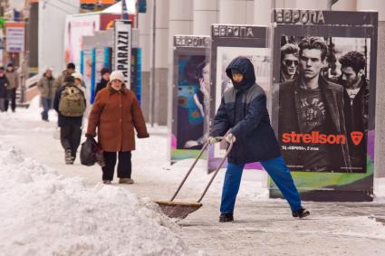 Екатеринбург. Гастарбайтер убирает снег с улицы.