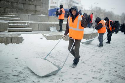 Екатеринбург. Гастарбайтеры убирают снег с асфальта во время снегопада.